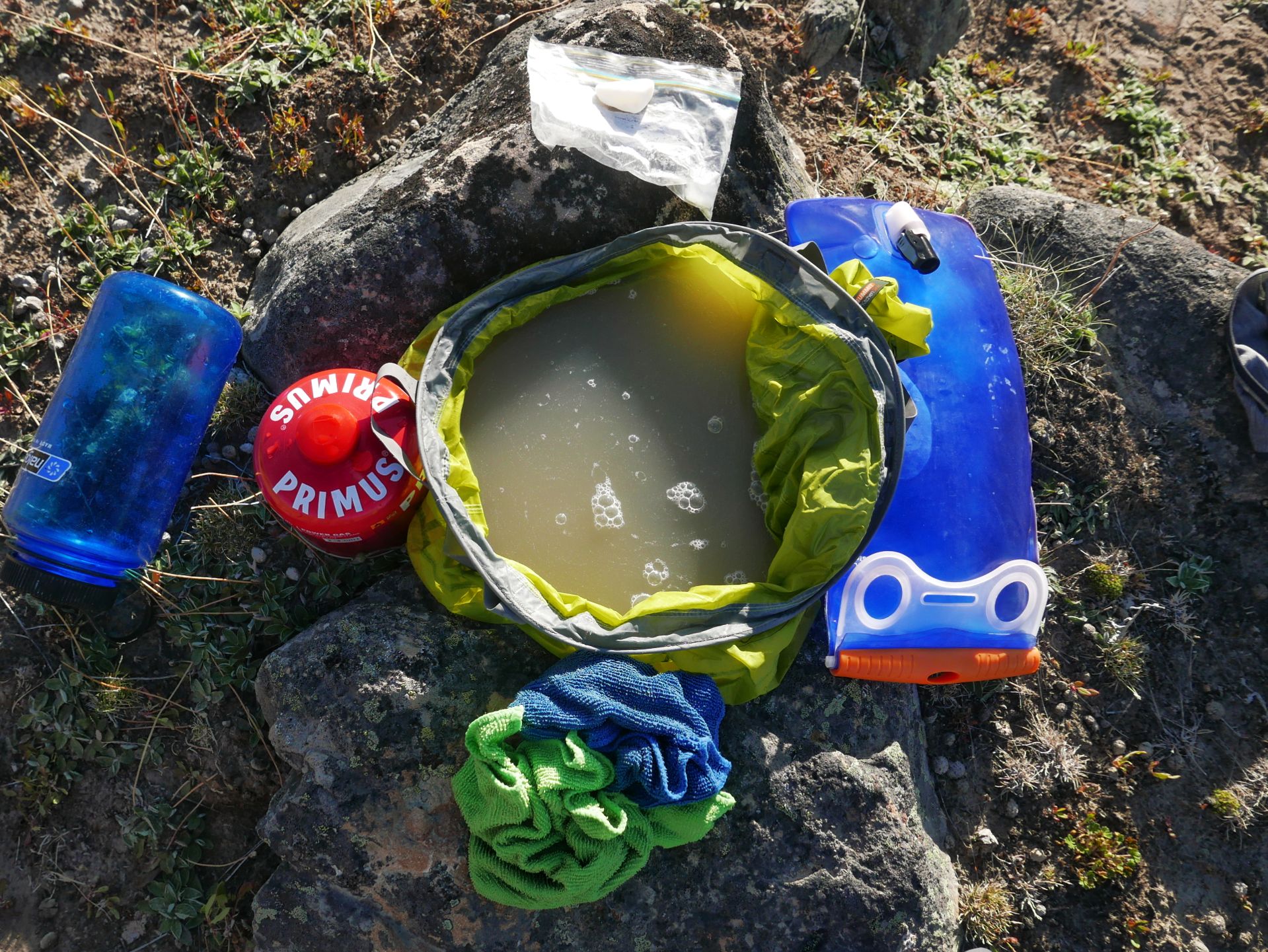 Waschschüssel mit dreckigem Wasser, Seife, Waschlappen